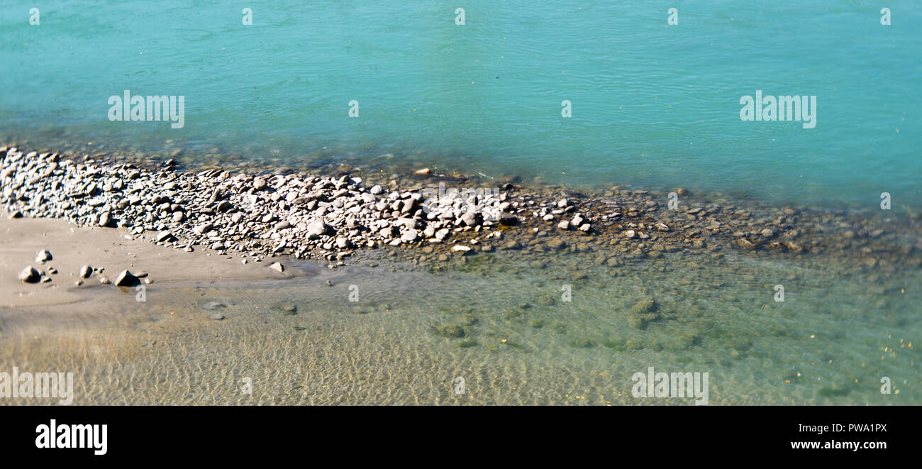 Rhine river with rocks and different color blue water in Switzerland near Maienfeld Stock Photo