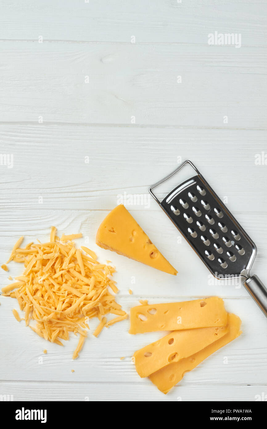 Emmental cheese on white wooden background. Fresh Swiss cheese, grater