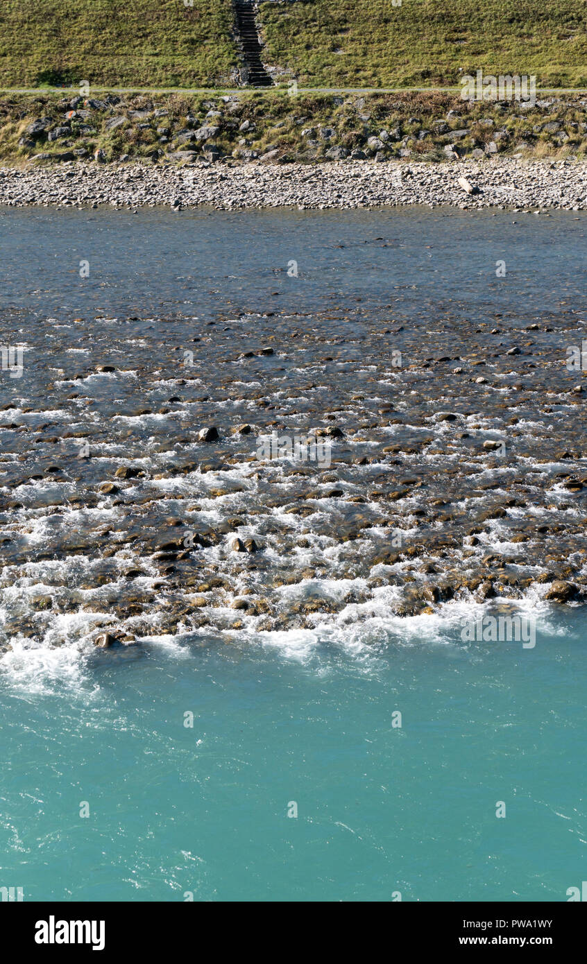 Rhine river with rocks and different color blue water in Switzerland near Maienfeld Stock Photo