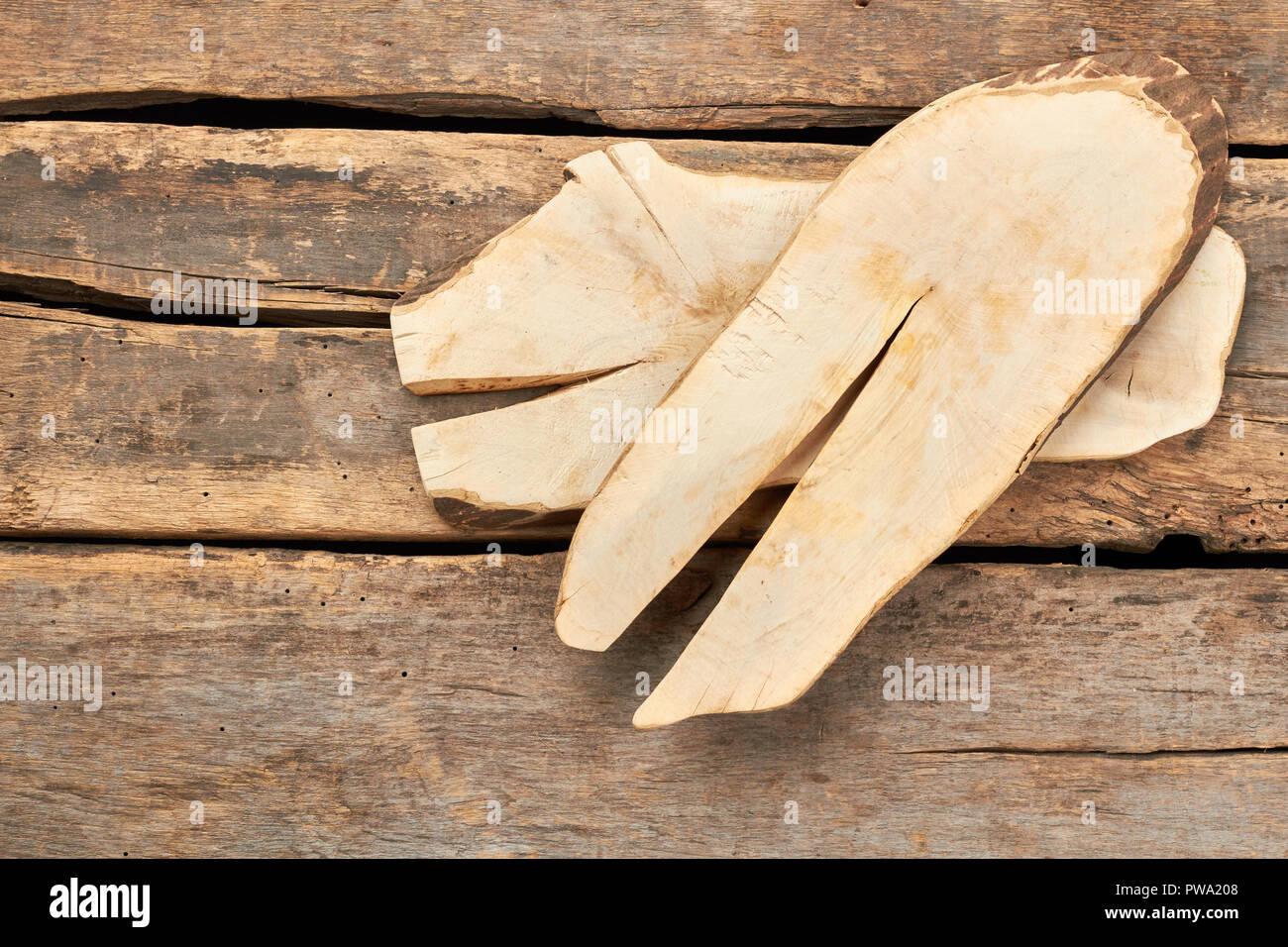 Slices of wood on rustic floor. Tree trunks on old wooden boards. Vintage kitchen tray. Stock Photo