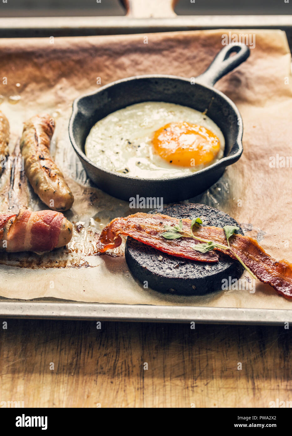Fry up breakfast tray with egg, black pudding, bacon and chipolata sausages Stock Photo