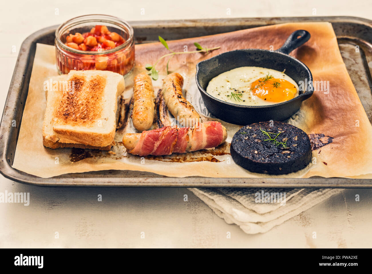 Full english fry up breakfast with egg, sausages, black pudding, baked
