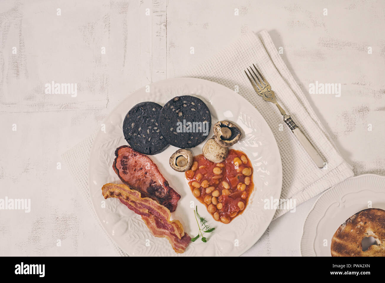 English fry up breakfast on white plate and rustic background Stock Photo
