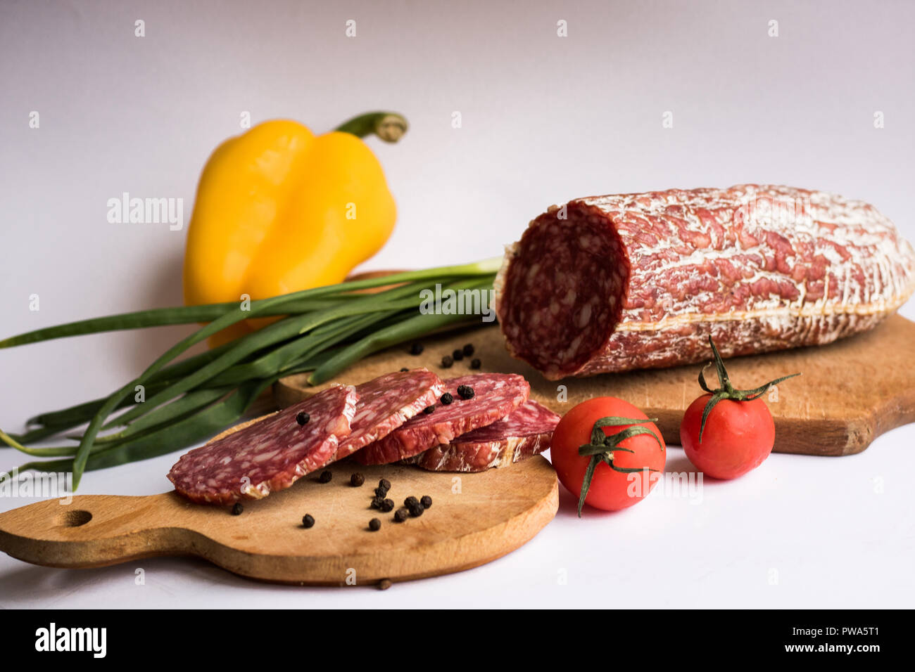Sausage pieces with yellow pepper and potatoes isolated on white