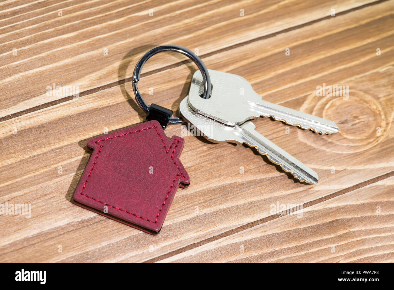 key chain with house symbol and keys on wooden background,Real estate