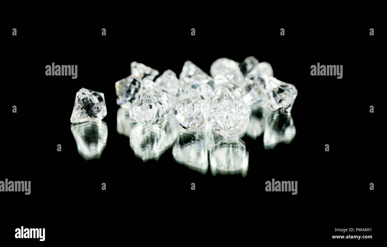 A bunch of shiny diamonds on a black mirror. Medium shot. Stock Photo