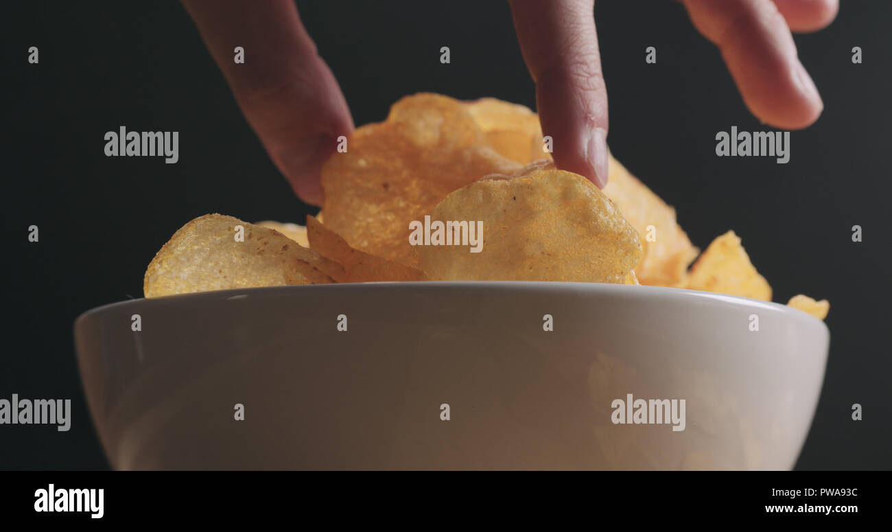 Closeup Man Hand Taking Potato Chip From White Bowl Low Angle Shot