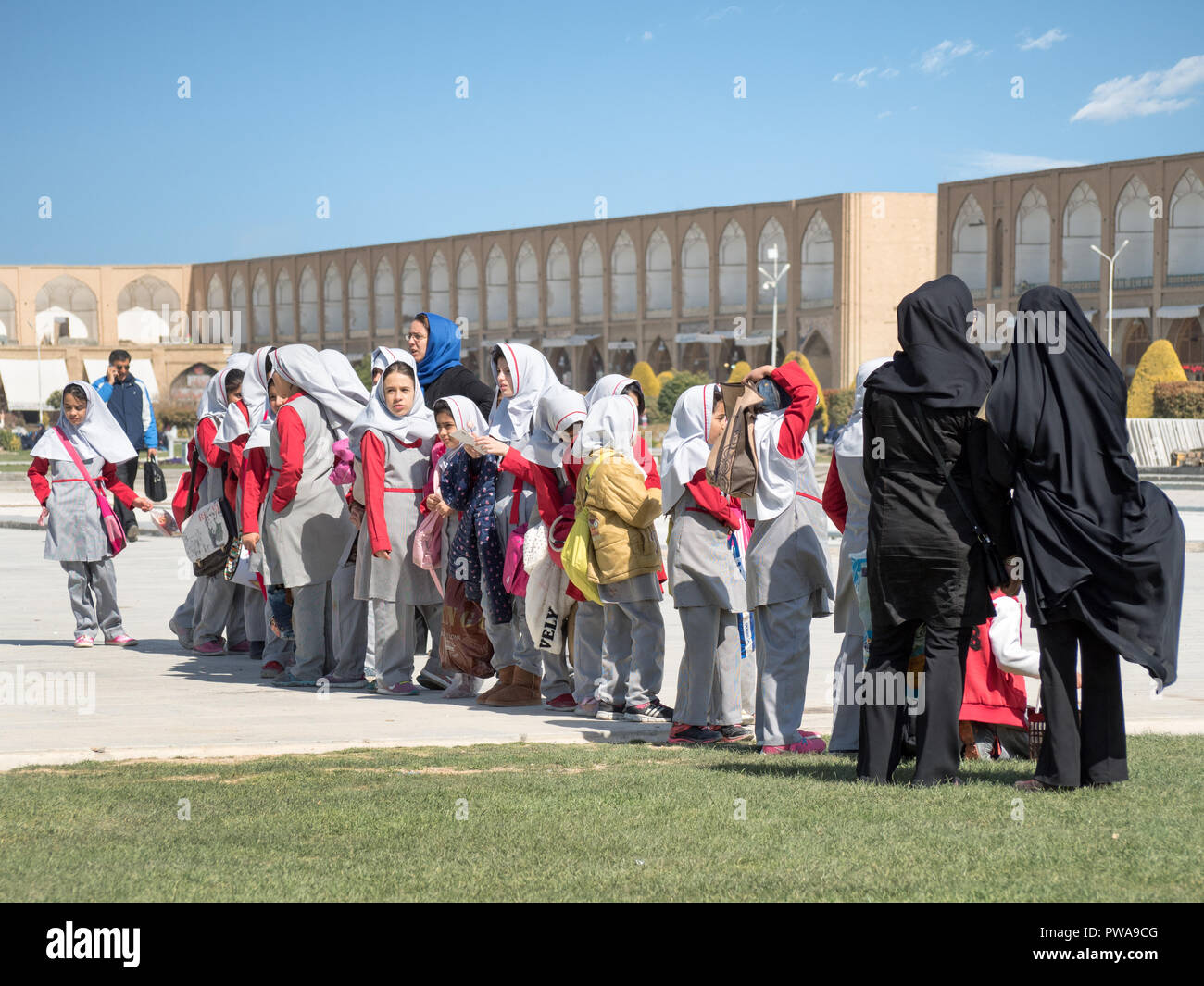 Isfahan, Iran - March 4, 2017 : primary school children with islamic veil visiting Naqsh-e Jahan square, a UNESCO famous site Stock Photo