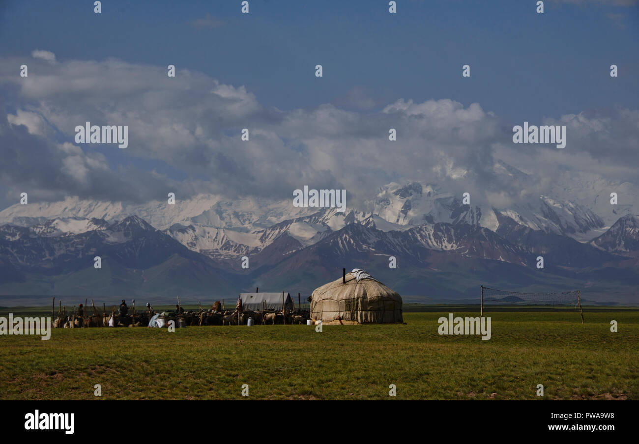 The High Pamirs rise over nomadic yurts along the Pamir Highway, Kyrgyzstan Stock Photo