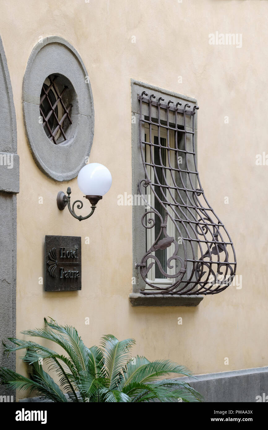 Unusual decorative wrought iron window security grill on house in old town of Pistoia, Tuscany, Italy, Europe, Stock Photo