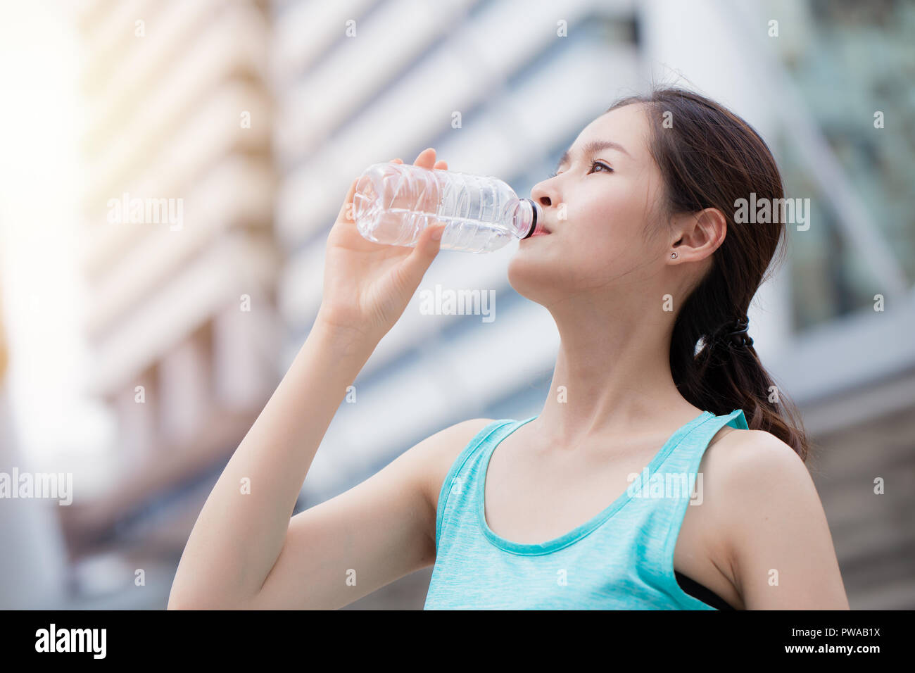 healthy sport cute asian teen drinking water city background Stock Photo