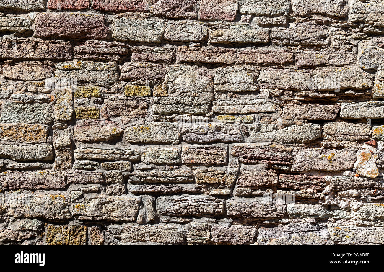 Weathered grey stone wall as creative background texture Stock Photo