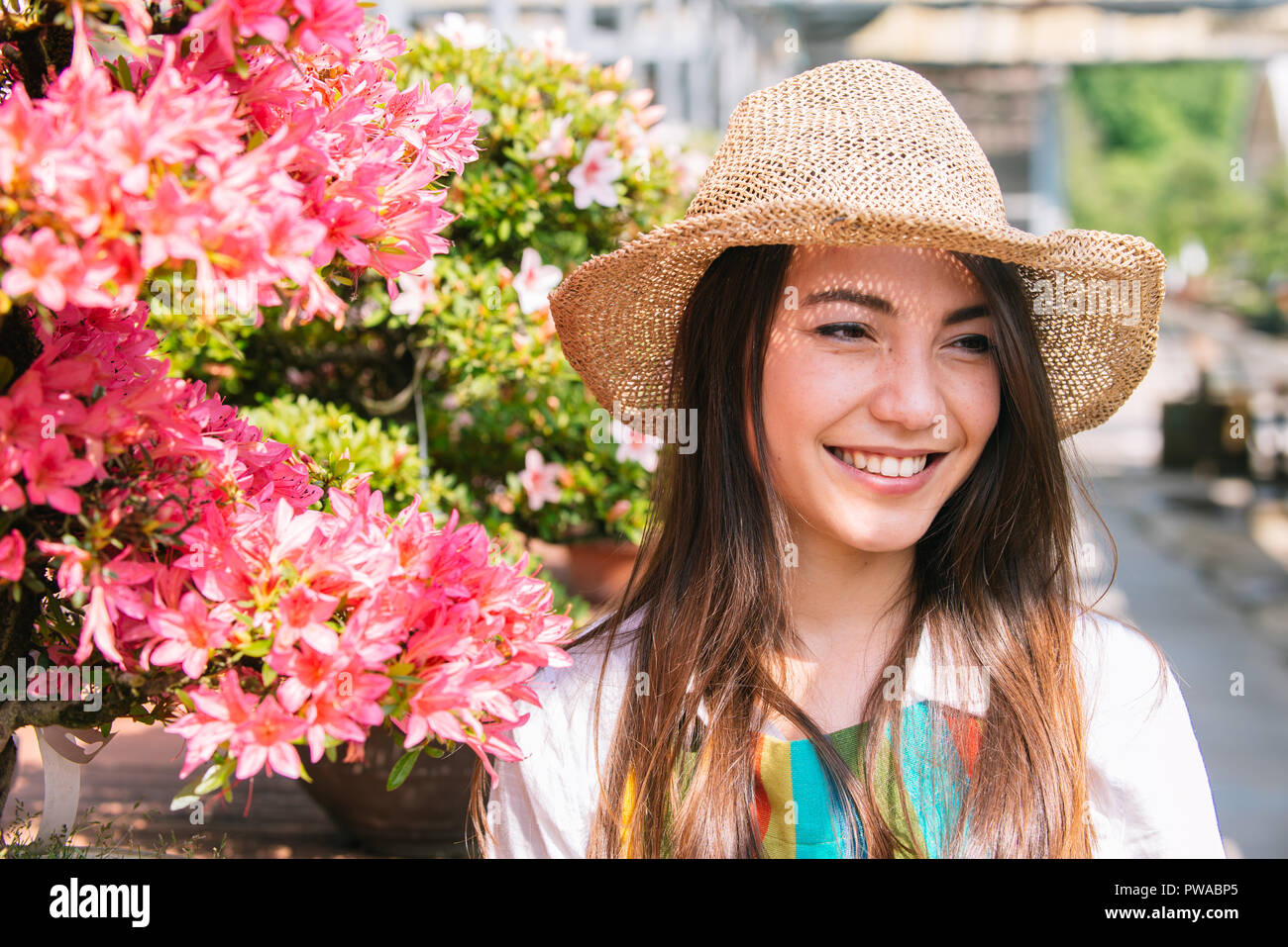 Pretty female gardener taking care of plants in her flowers and plants