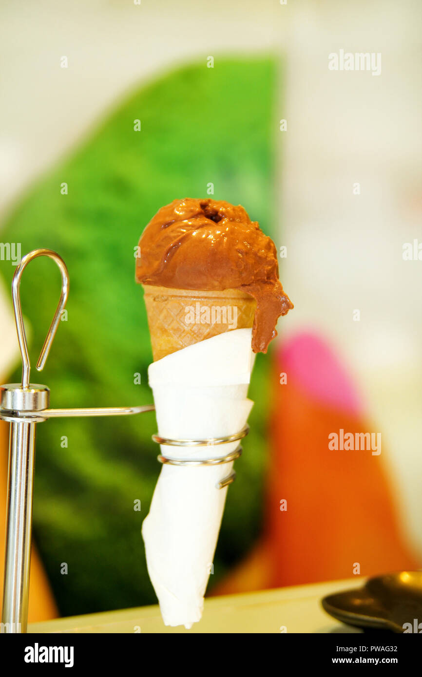 Ice cream holders in ice cream shop, closeup. Waffle cone with ice cream of chocolate on holder