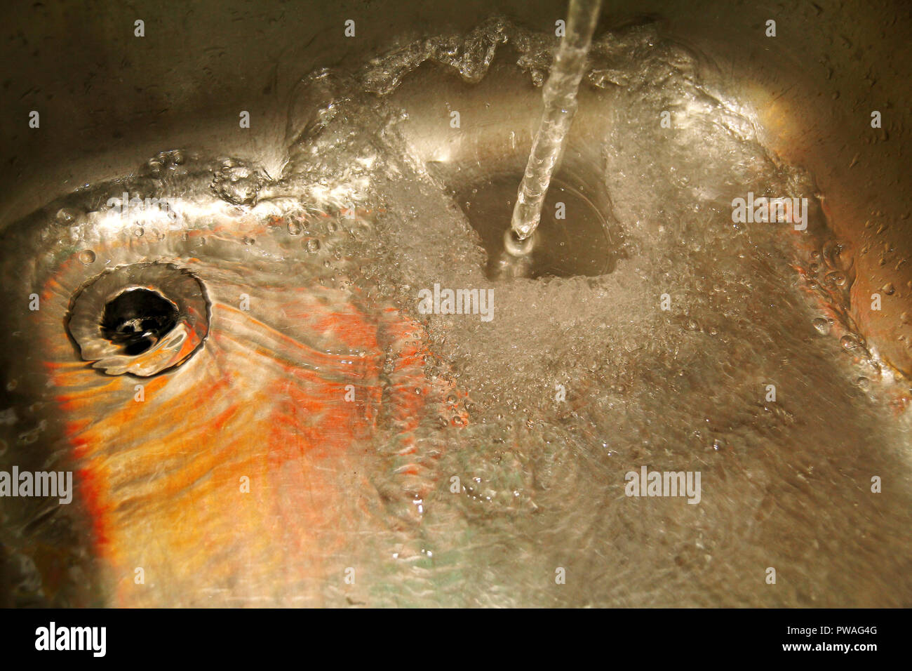 Water splashing down the sink on stainless kitchen sink. Scene water