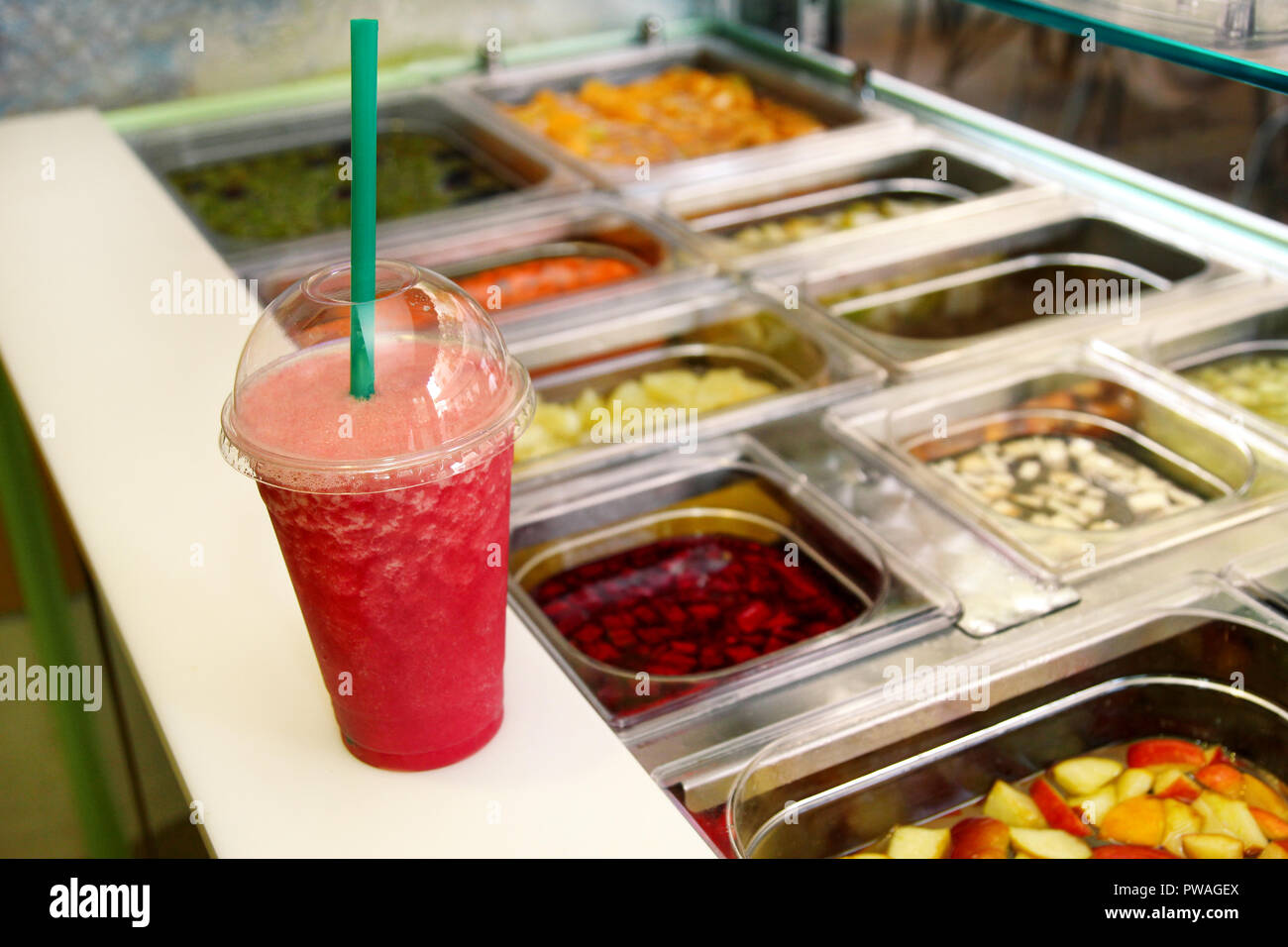 Fruit smoothie ready for sales in plastic cup with straw. Take away