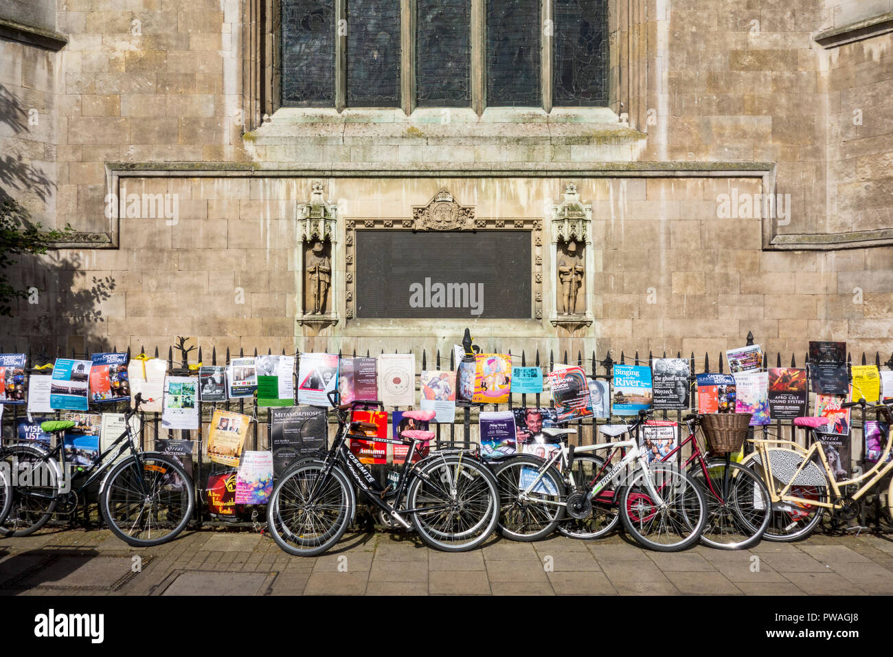 Bicycles chained to railings surrounded by posters or flyers outside Great St Mary's Church, Cambridge, UK Stock Photo