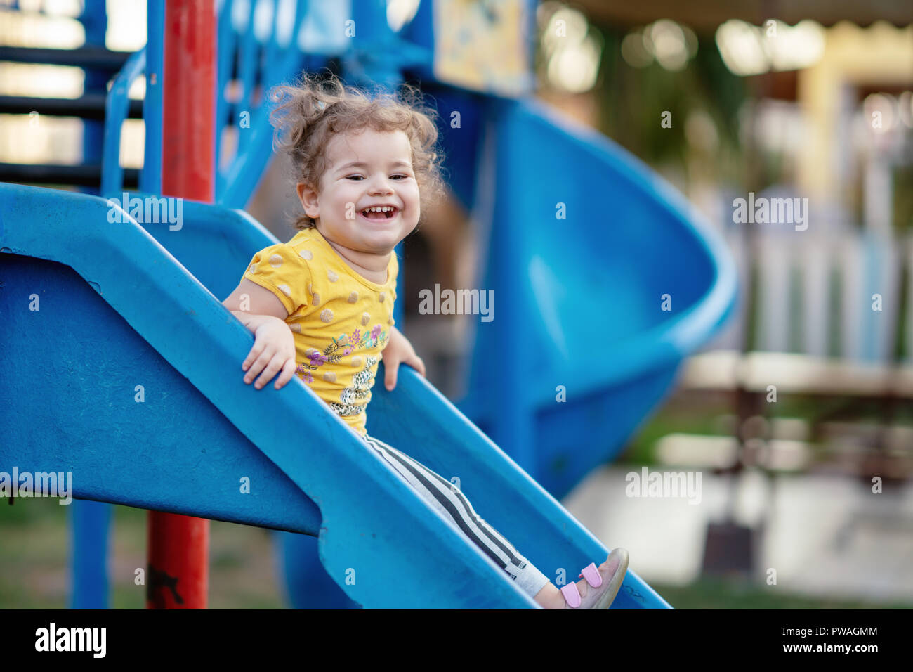 Little Toddler Playing At Playground Outdoors In Summer. Stock Photo
