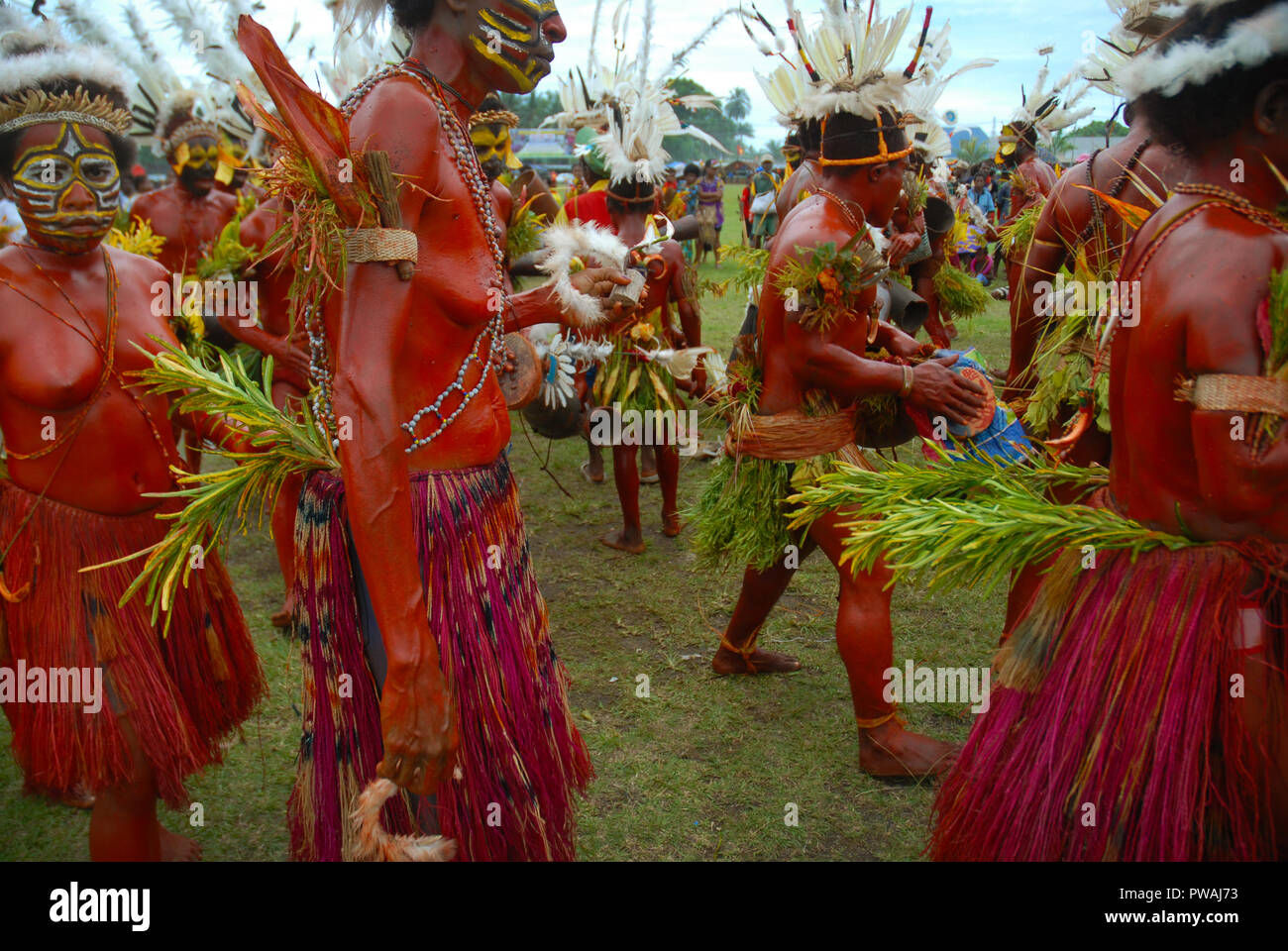 Colourfully dressed and face painted women dancing as part of a Sing ...