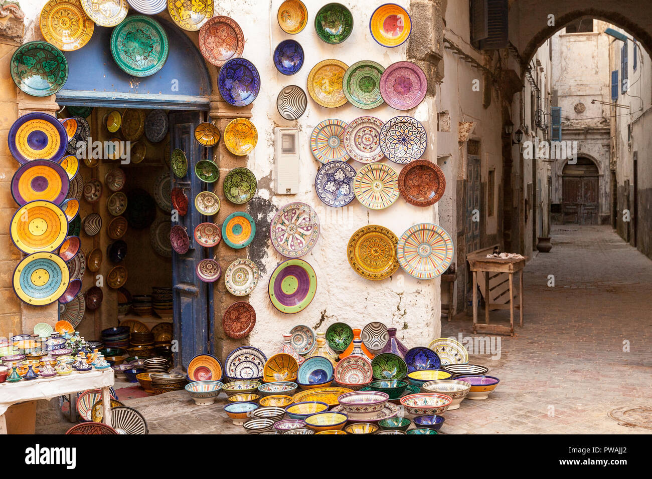 Morocco Essaouira colorful ceramics and pottery displayed for sale outside a store in a pedestrian shopping alley. Colorful and atmospheric. Stock Photo
