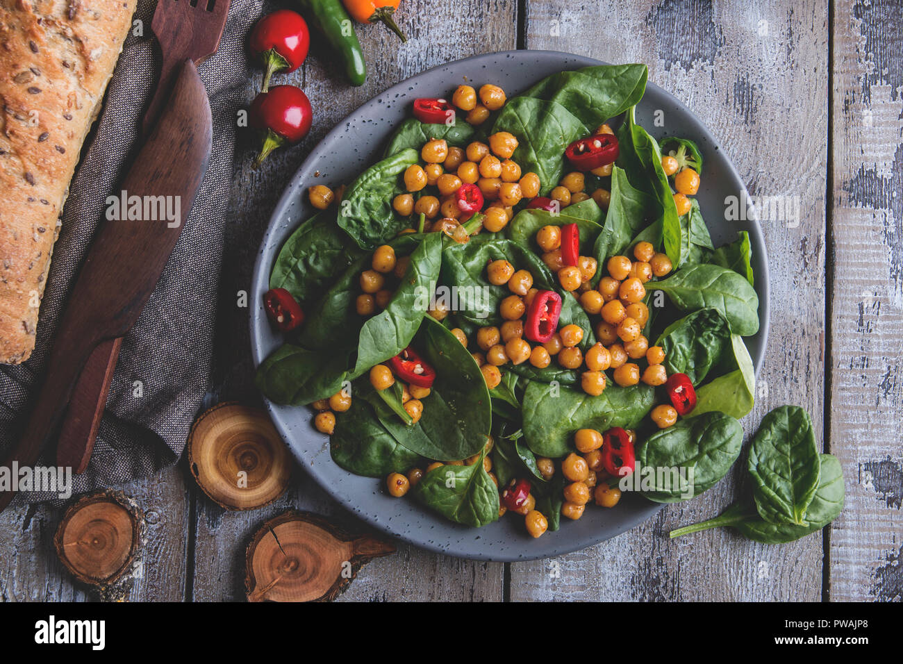 Chickpea and veggies salad with spinach leaves, healthy homemade vegan food, diet. Stock Photo