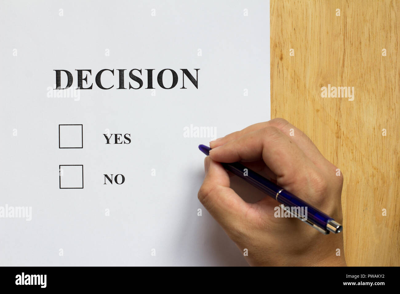 Decision paper with yes and no choice with man hold the pen on wood background Stock Photo