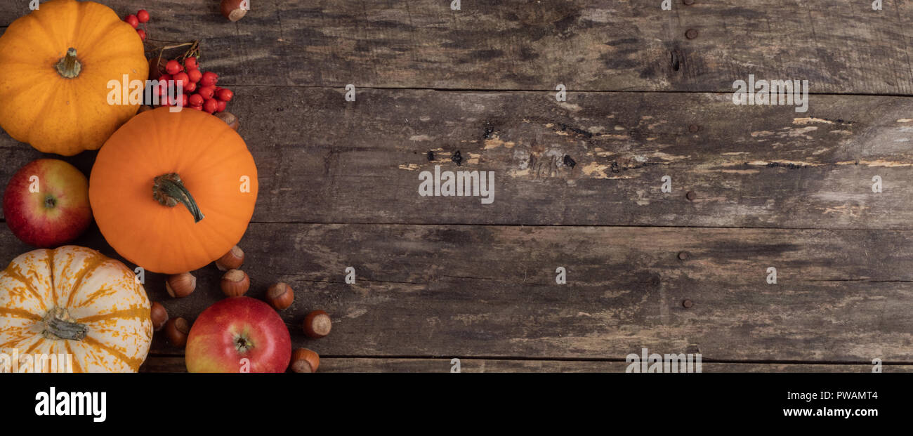 Autumn harvest still life with pumpkins , apples , hazelnuts on wooden ...