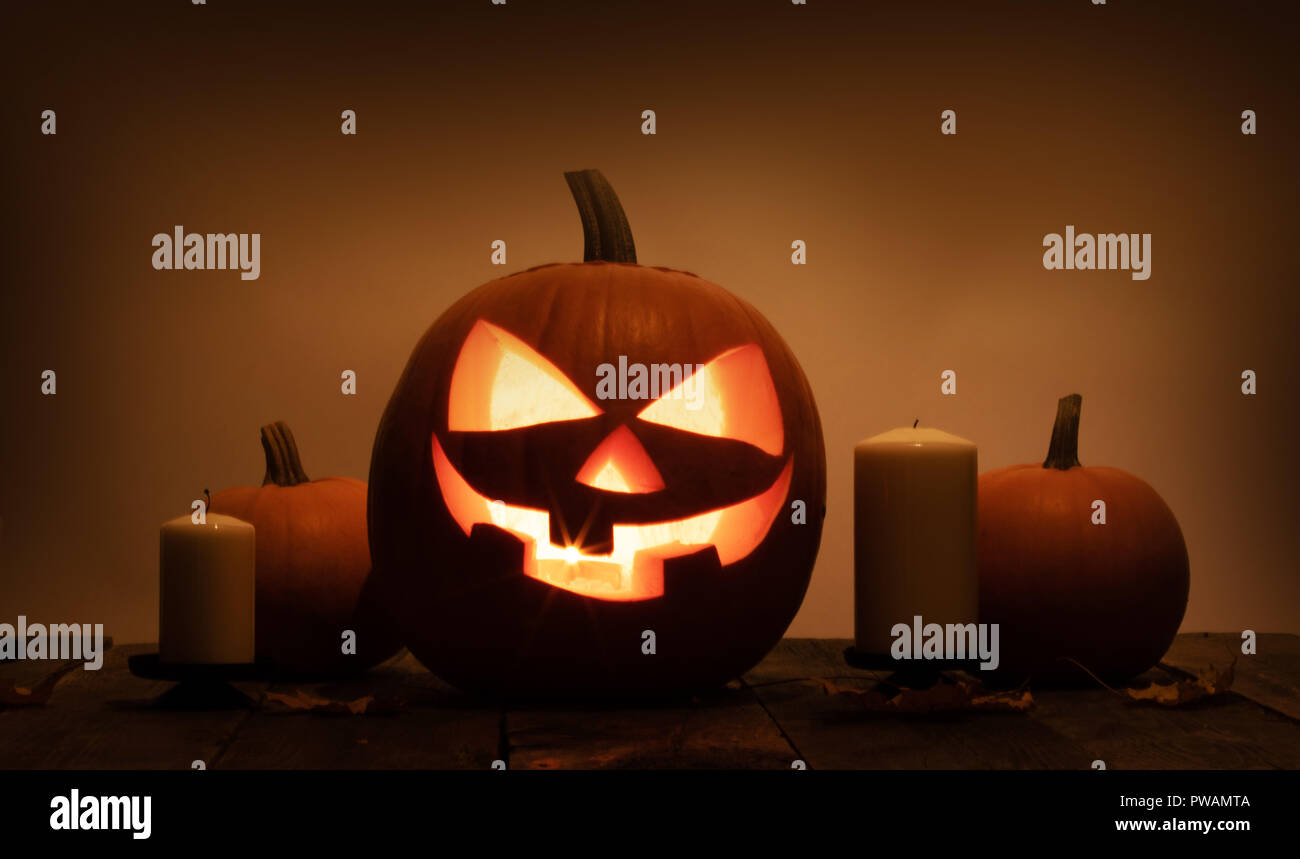 Group of Halloween pumpkin head jack o lantern and candles on dark ...