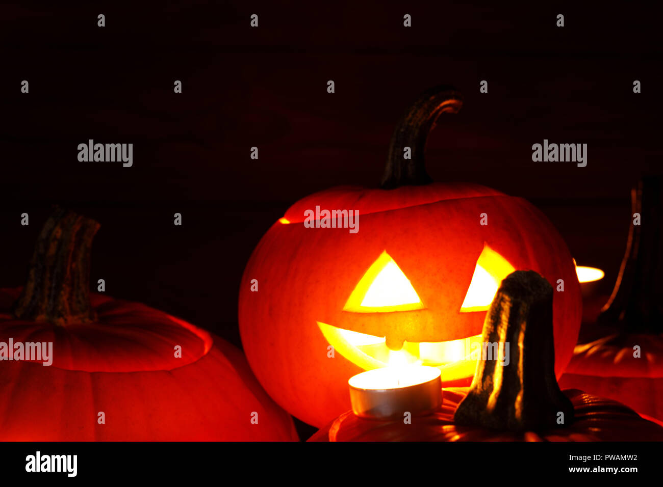 Group of Halloween pumpkin head jack o lantern and candles on dark ...