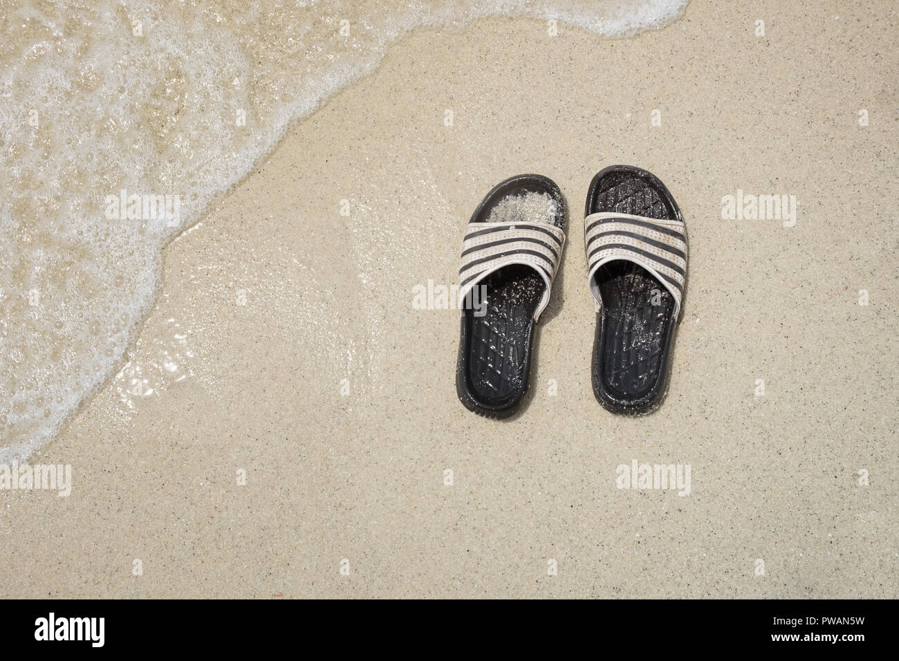 Summer travel concept,Top view flip flops on sand beach with copy space ...