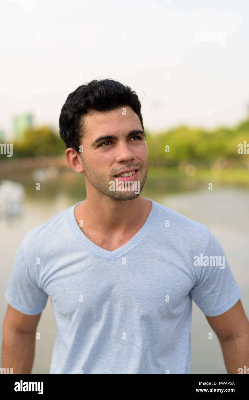Young handsome Hispanic man relaxing in the park Stock Photo