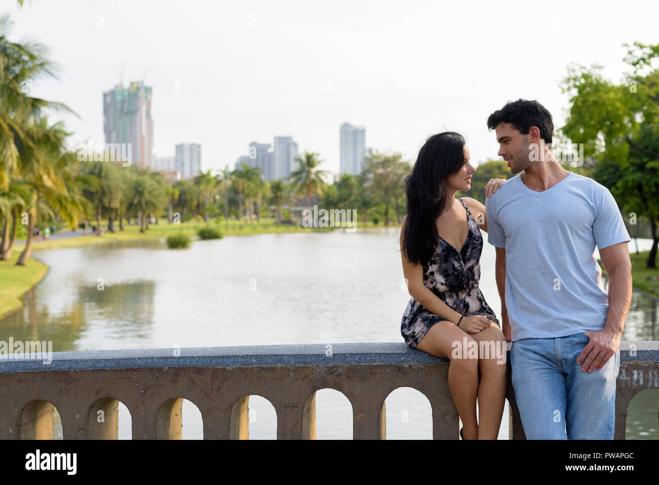 Young Hispanic couple relaxing in the park together Stock Photo - Alamy