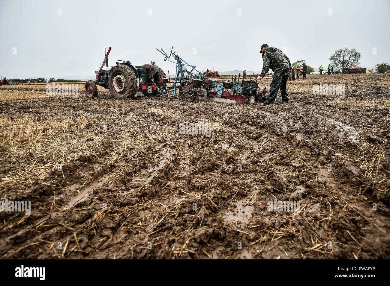 A ploughman adjusts the height of his plough after turning during the