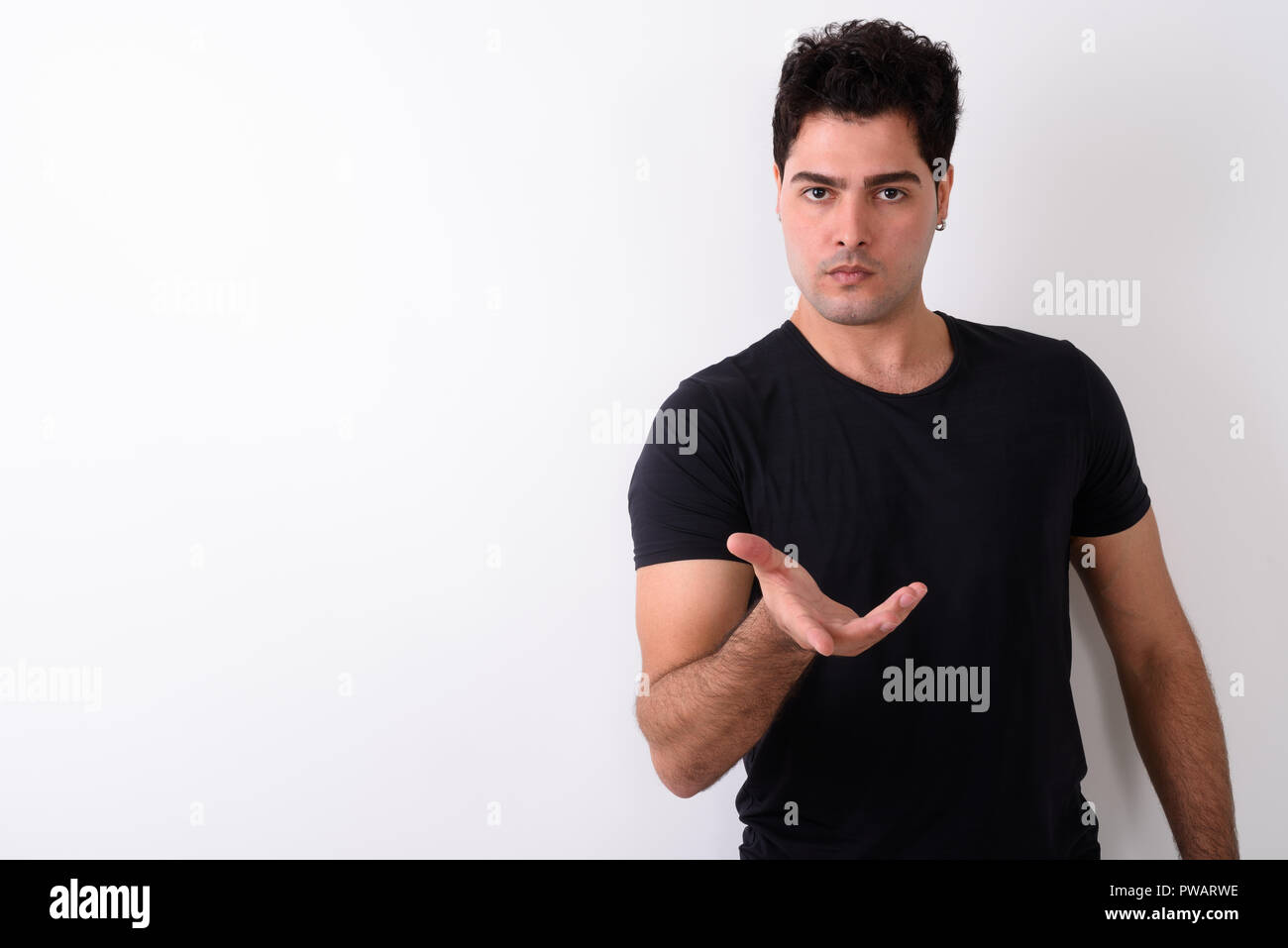 Young handsome Persian man against white background  Stock Photo