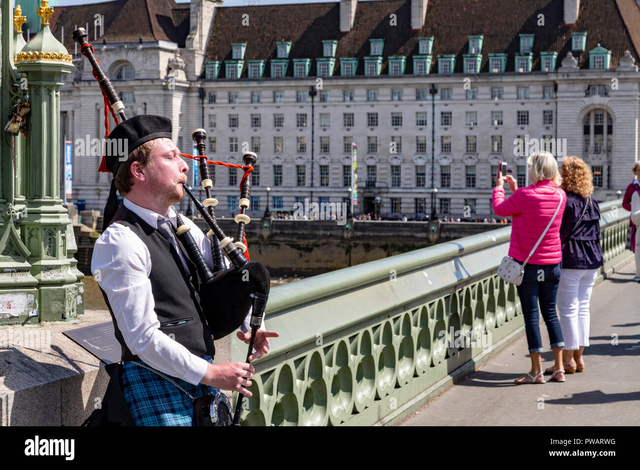 A Man Plays The Bagpipes On Westminster Bridge, London, England Stock