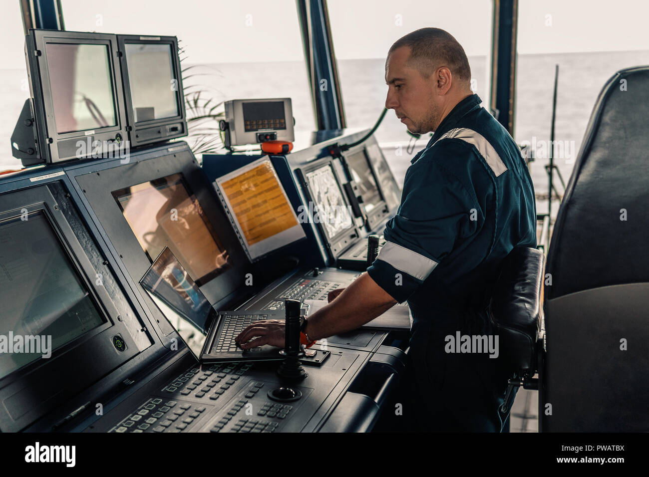 Marine navigational officer is using laptop or notebook at sea Stock ...