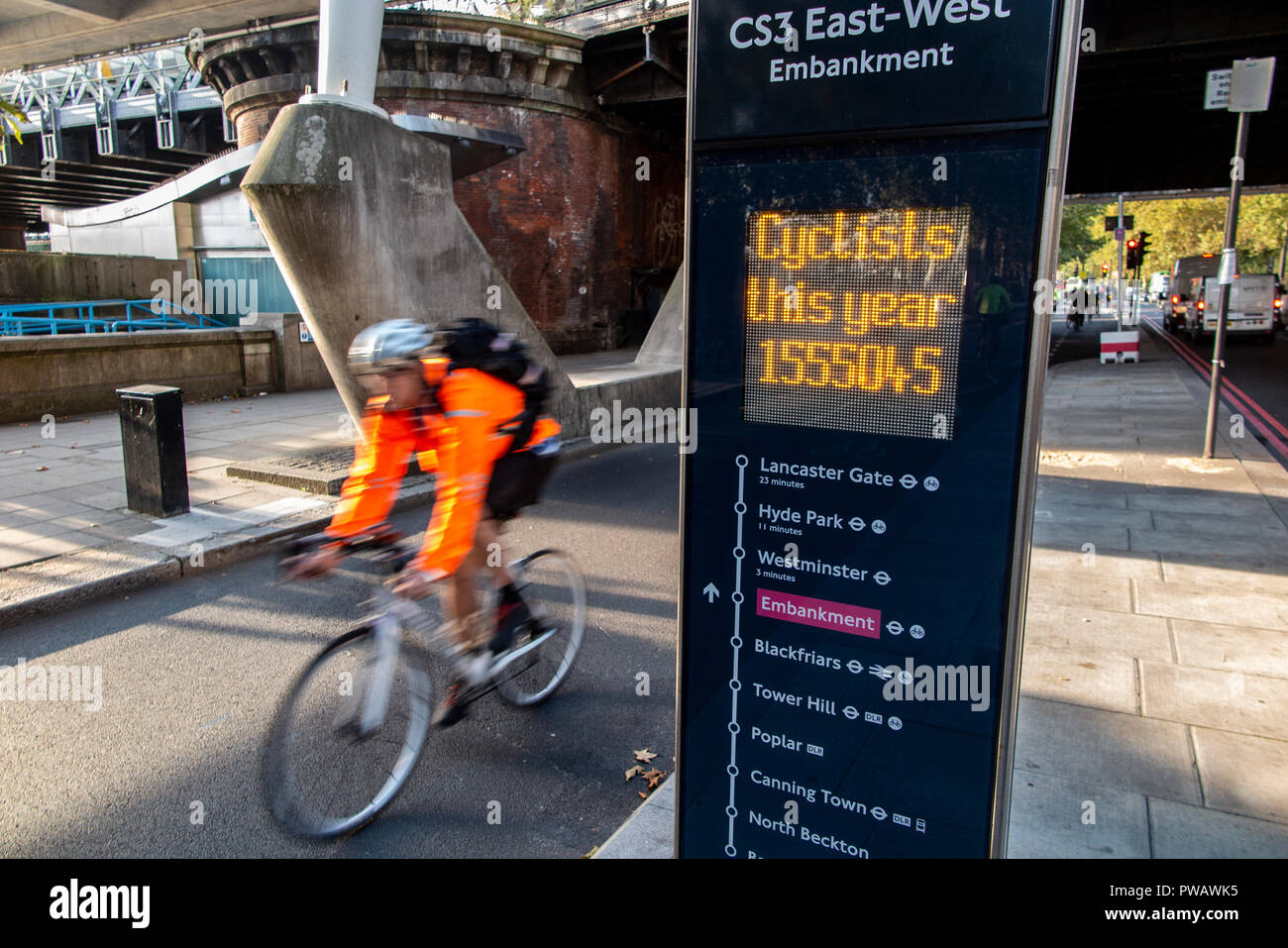 Riders cycling through a digital bicycle rider counter in London Stock Photo