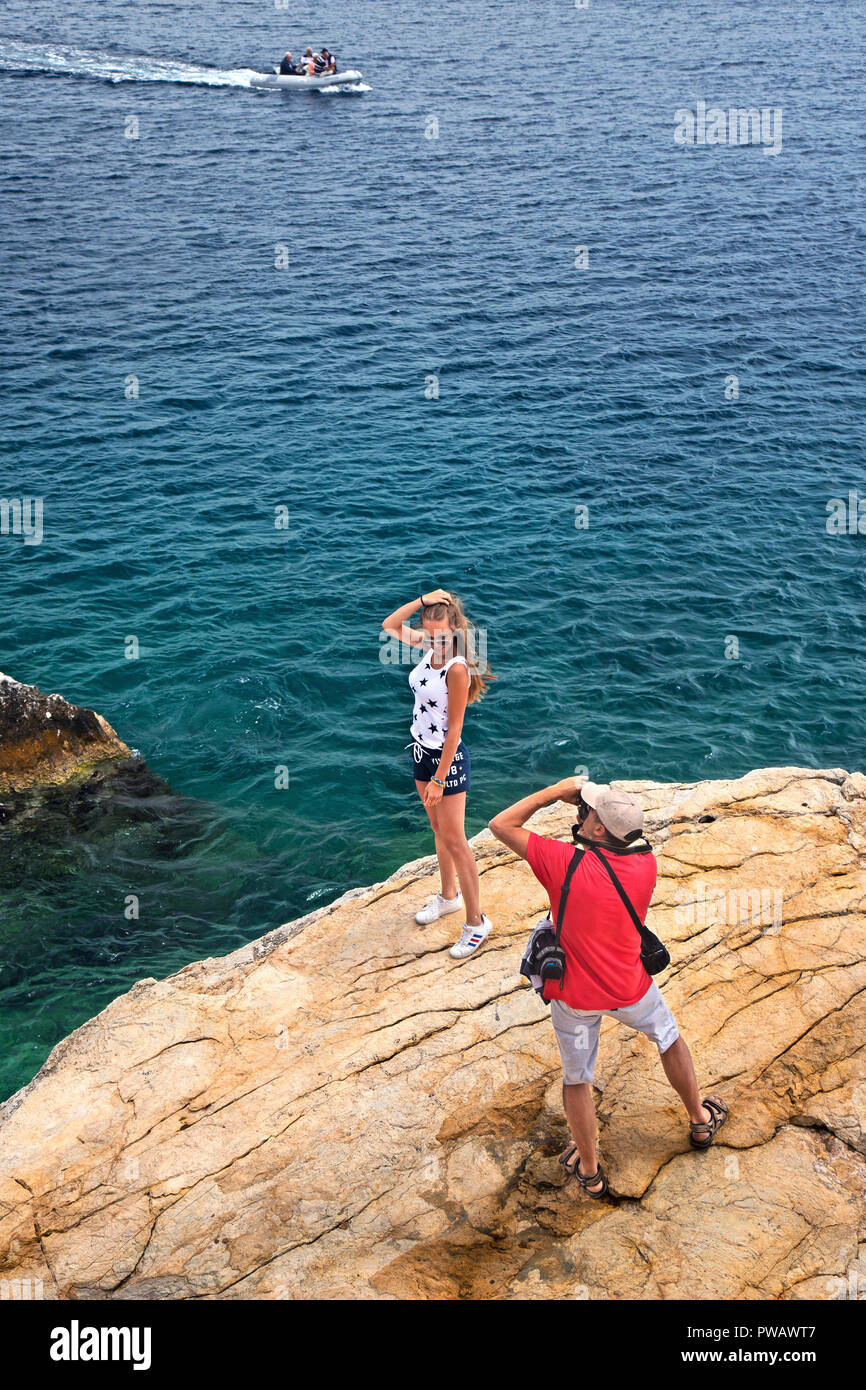 Father photographing his daughter at Plakes neighborhood, Skiathos town, Skiathos island, Northern Sporades, Magnessia, Thessaly, Greece. Stock Photo