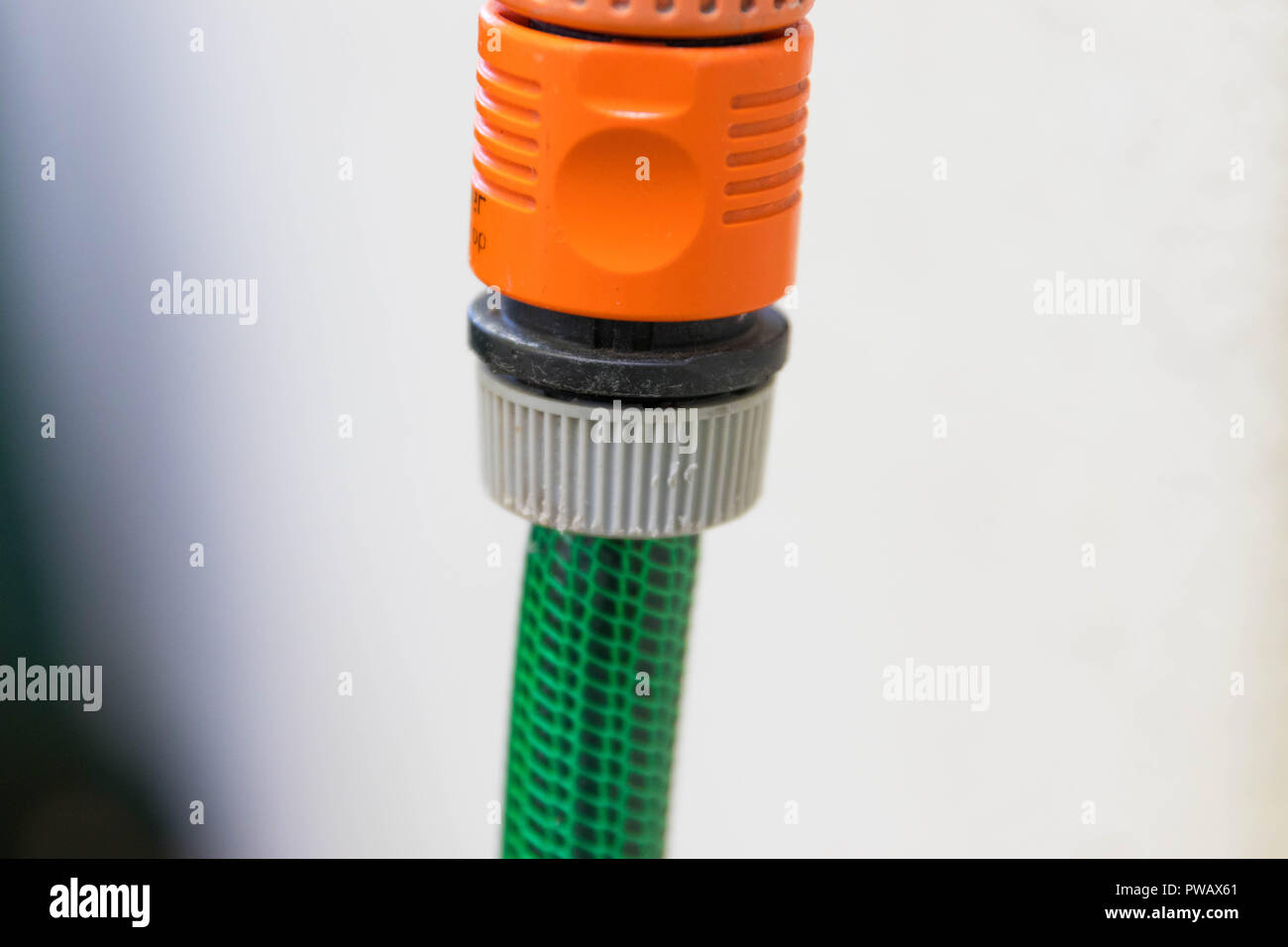 Garden rubber plastic tube tip hose pipe water isolated close up orange