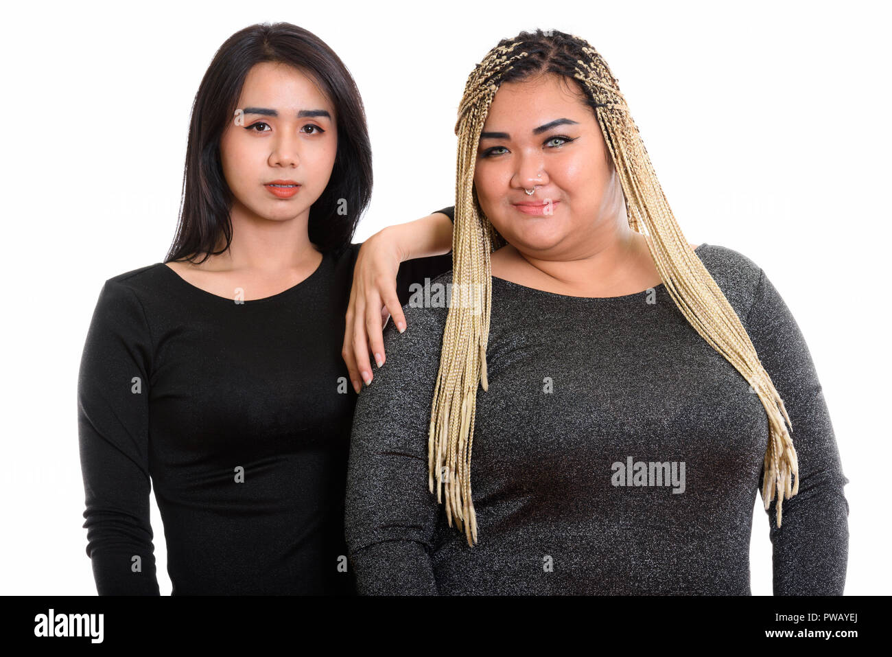 Young Asian transgender woman resting hand on fat Asian woman Stock Photo