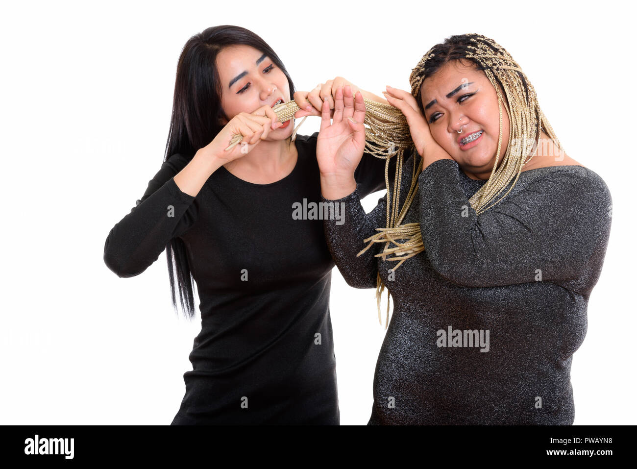 Young Asian transgender woman eating and pulling the hair of fat Stock Photo