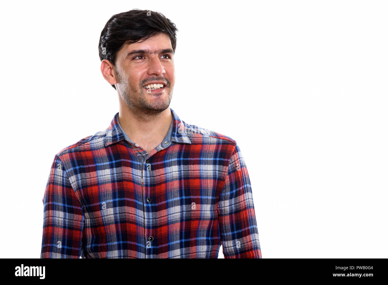 Studio shot of young happy Persian man smiling and thinking whil Stock ...