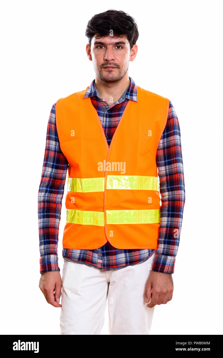 Studio shot of young Persian man construction worker standing Stock Photo