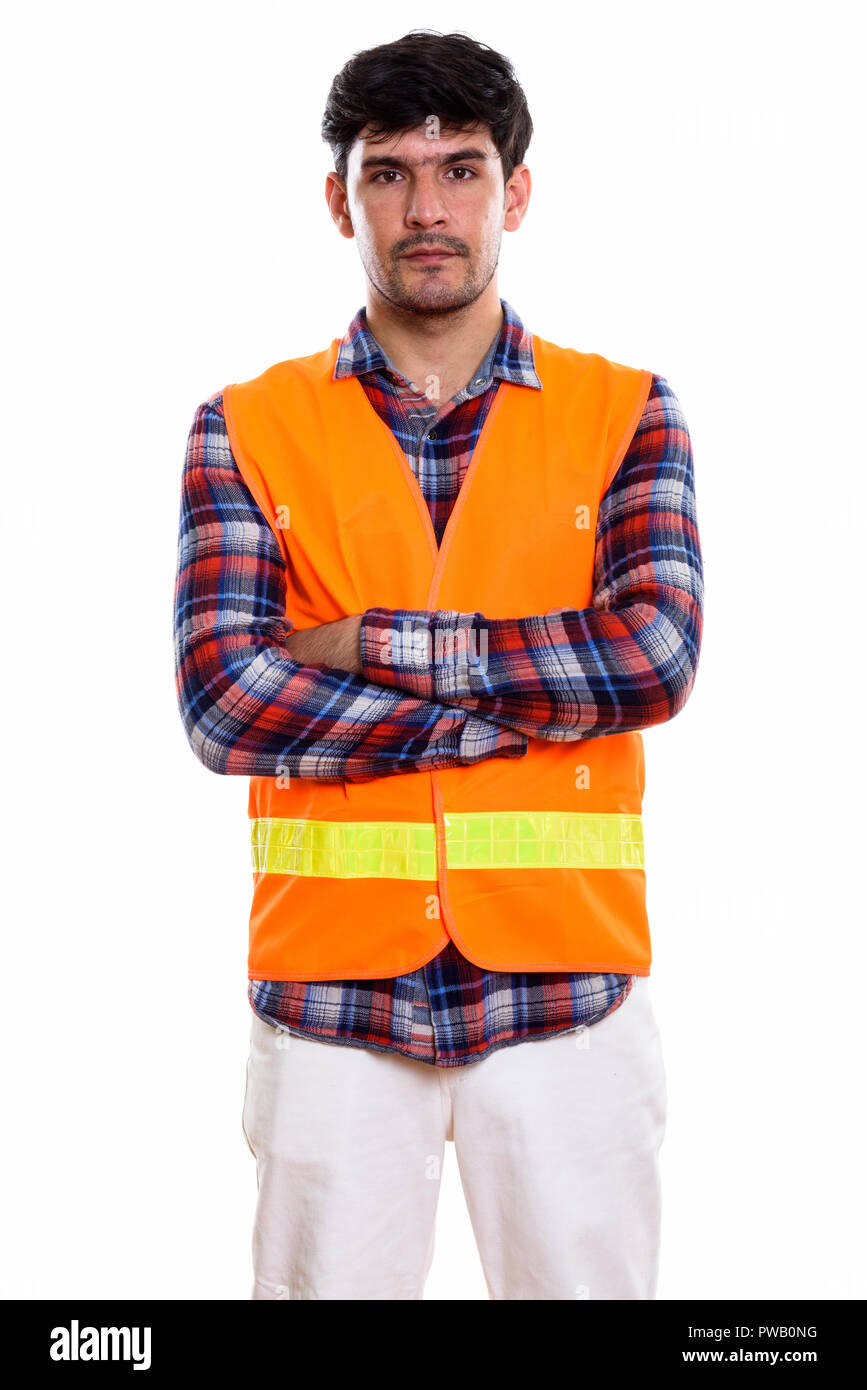 Studio shot of young Persian man construction worker standing wi Stock Photo