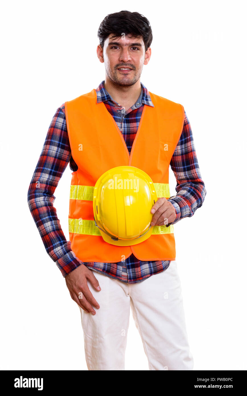 Studio shot of young Persian man construction worker standing wh Stock Photo