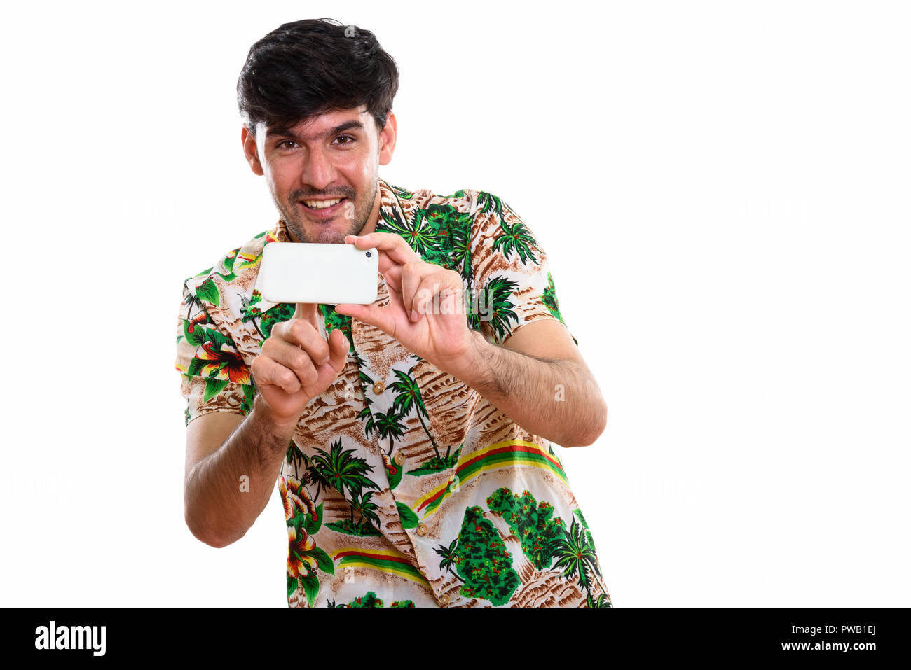 Studio shot of young happy Persian man smiling while taking pict Stock ...
