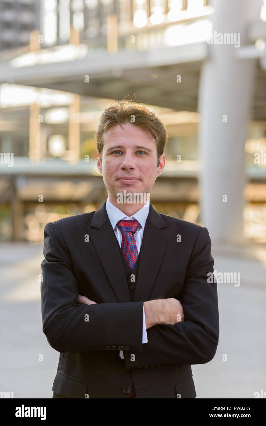 Businessman with arms crossed in front of modern building at Ban Stock ...