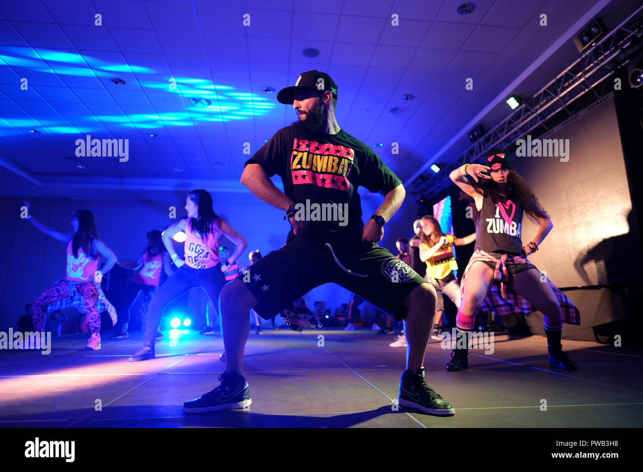 Instructors dancing energetically on stage during a Zumba class Stock Photo