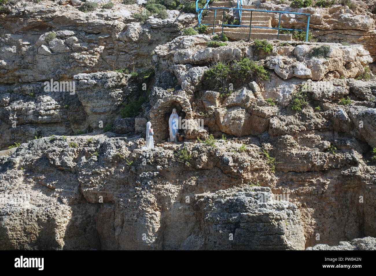 A Madonna grotto set into the cliffs of the Blue Lagoon, Comino Island, Malta Stock Photo
