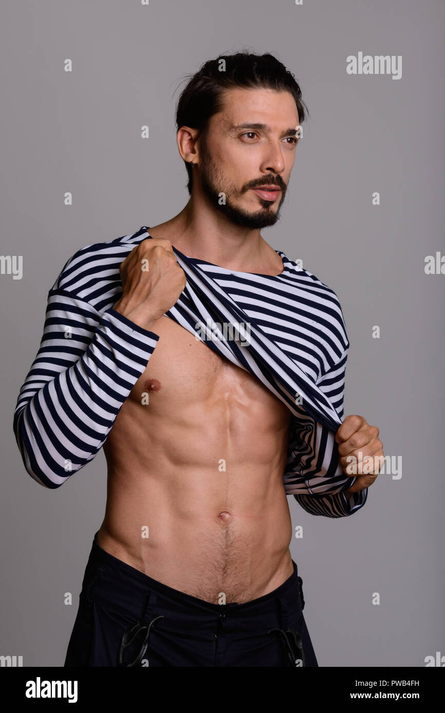 Studio shot of handsome man showing abs and thinking  Stock Photo